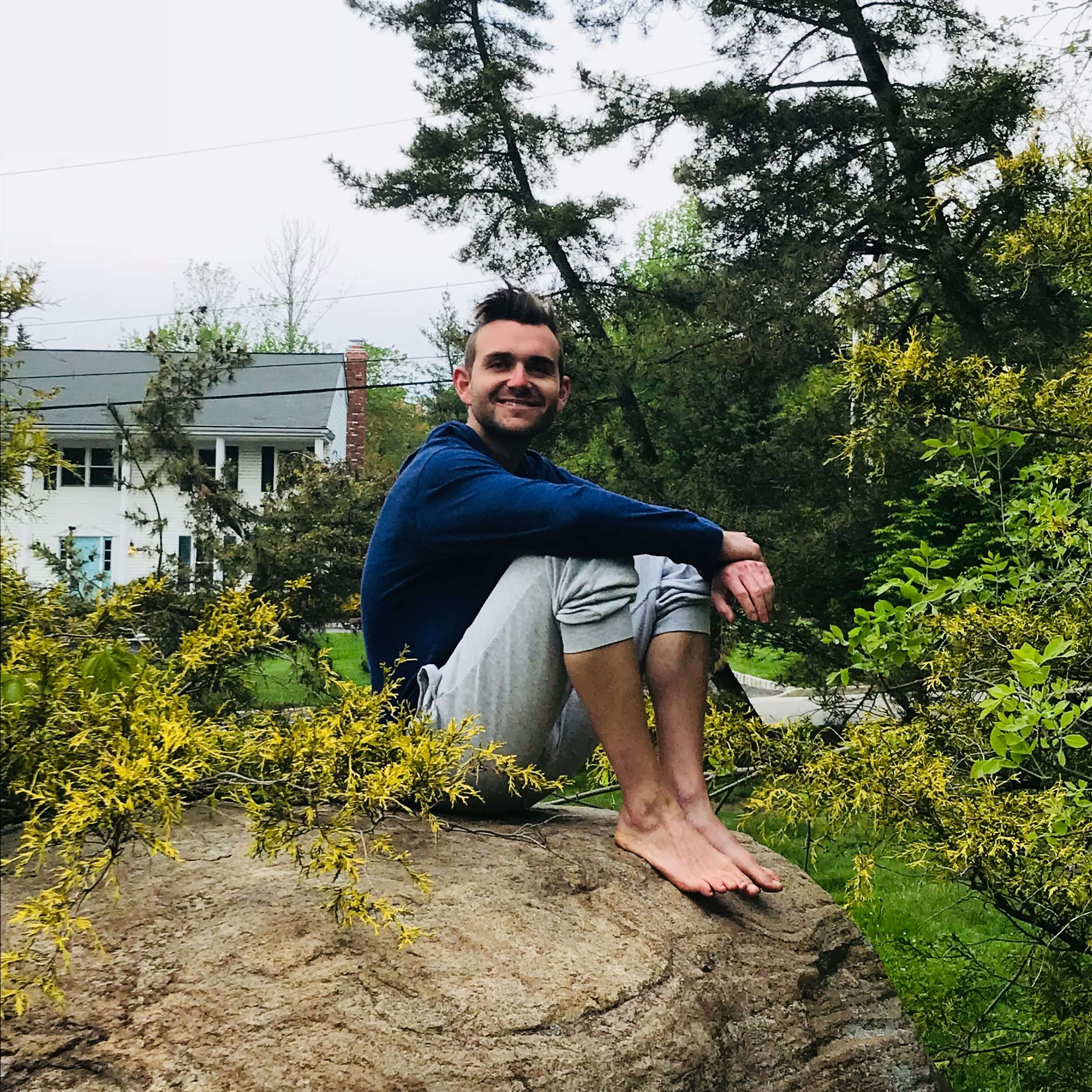 Greg sitting on a rock
